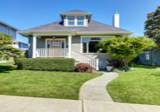 Single-family American craftsman house exterior. Blue sky background and nicely trimmed front yard. Northwest, USA