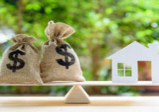 Is a green home worth it?Home on a scale with bags of money